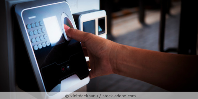 Man scanning his fingerprint at the entrance for biometric authentication.